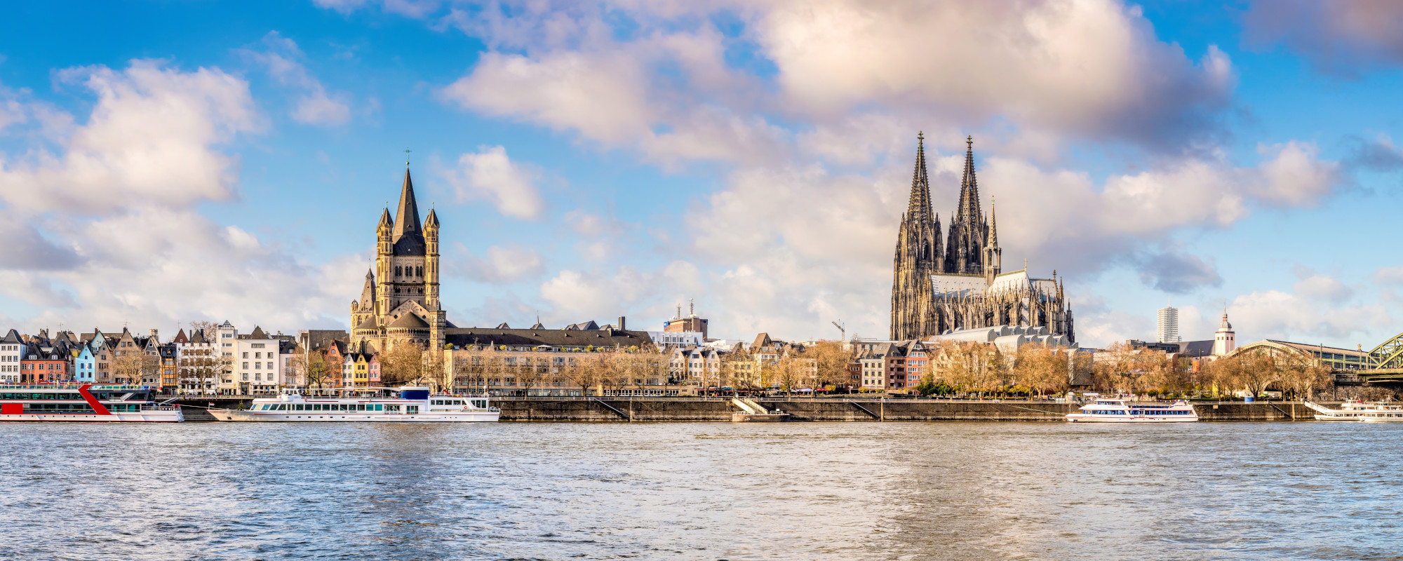 Blick auf die Skyline in Köln mit Dom und anliegenden Schiffen auf dem Rhein