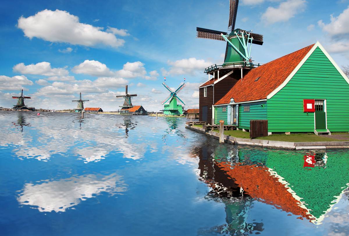 Blick auf Windmühlen am Wasser und grünem Haus