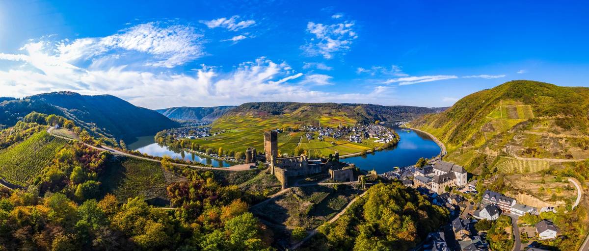Panoramablick auf Flusskurve mit Weinbergen an Hängen unterb blauem Himmel