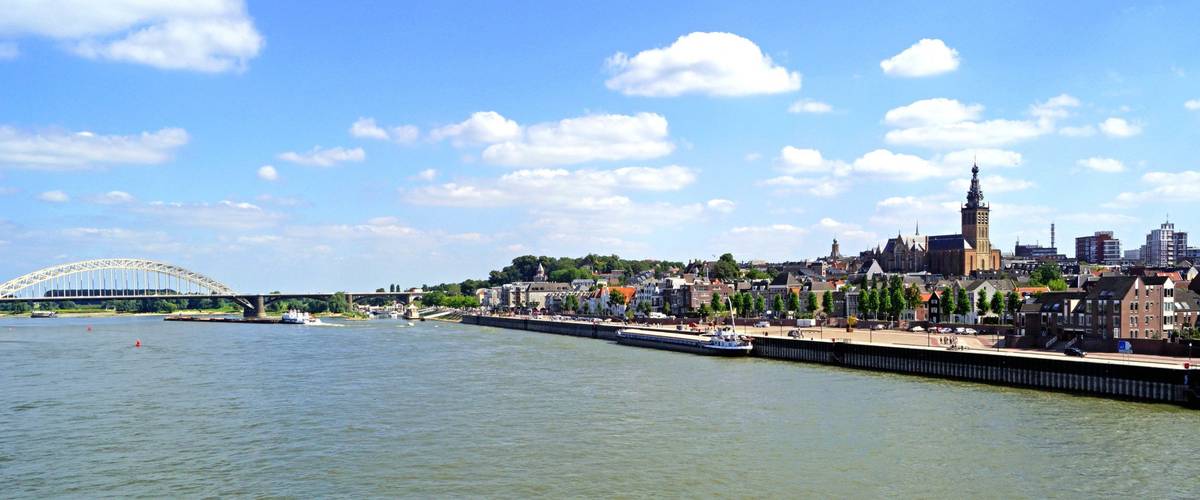 Panoramablick auf Fluss und Stadt mit Brücke, Gebäuden bei Tag