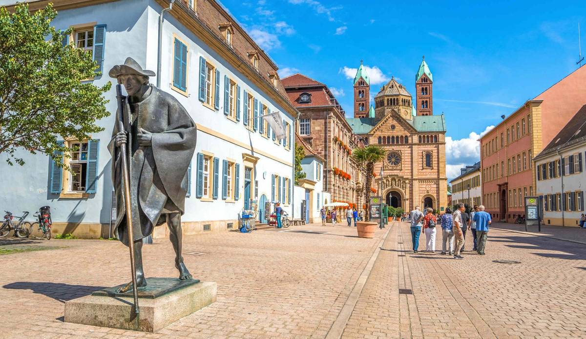 Blick auf Denkmal und Straße mit Gebäuden und Menschen unter blauem Himmel