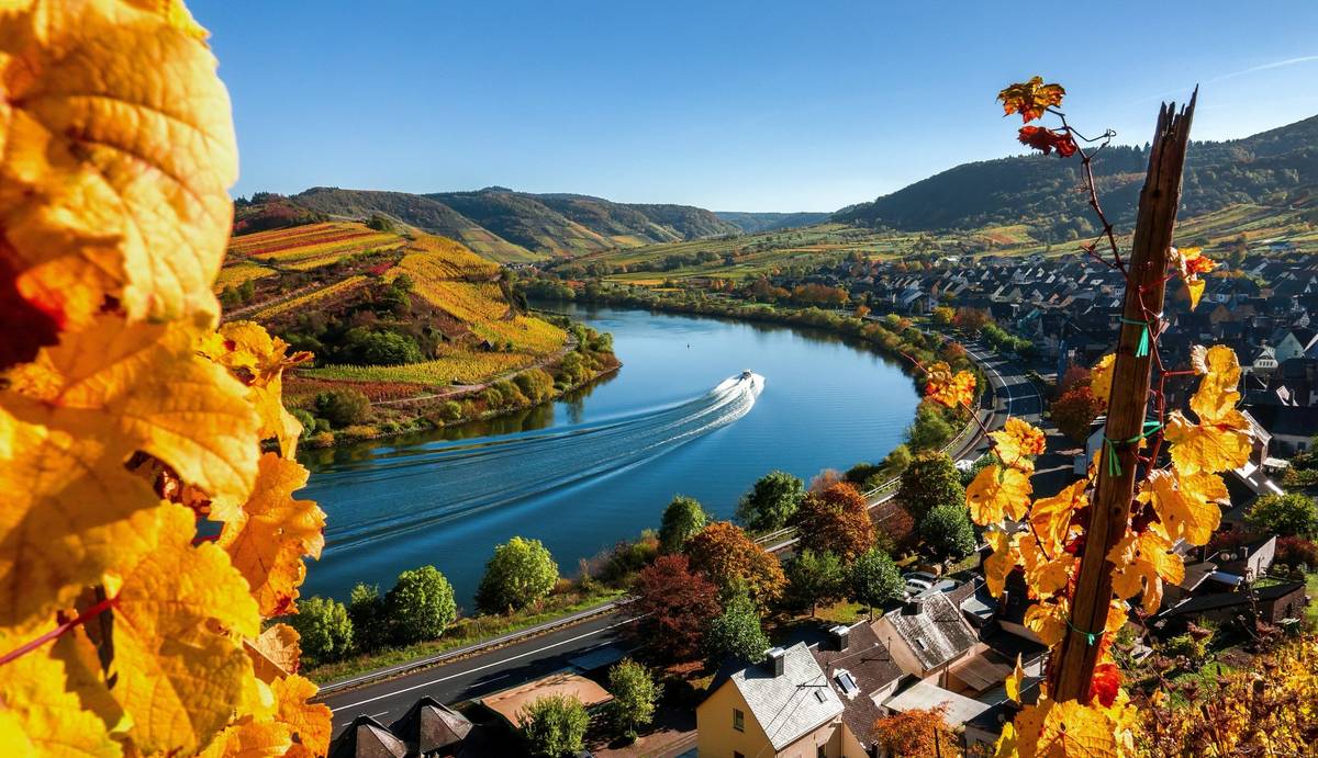 Panoramabild einer Flusskurve mit treibendem Schiff in herbstlich gefärbter Landschaft am Tag
