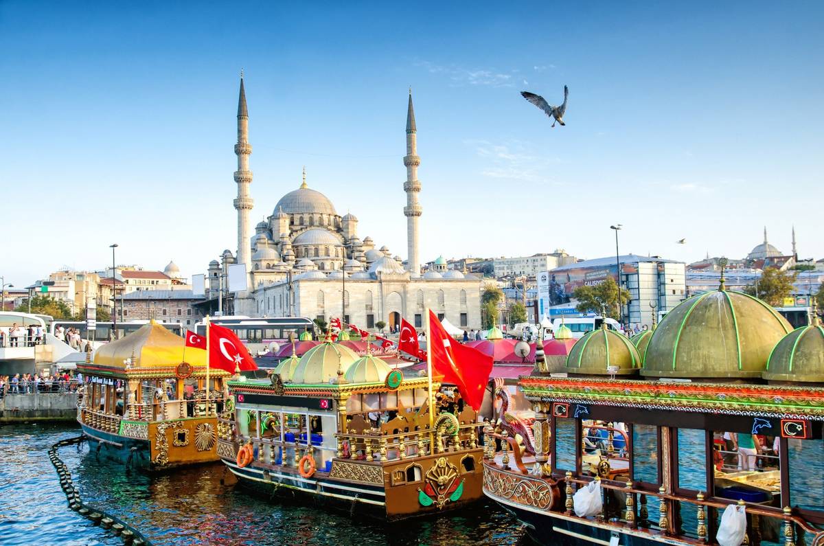 Blick auf bunte und geschmückte Schiffe vor imposanter Moschee
