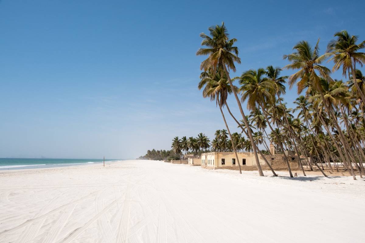 Weißer Strand in der Stadt Salalah mit Palmenpanorama