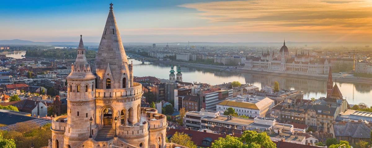 Panoramablick auf Stadt mit Kirchturm im Vordergrund bei Sonnenuntergang