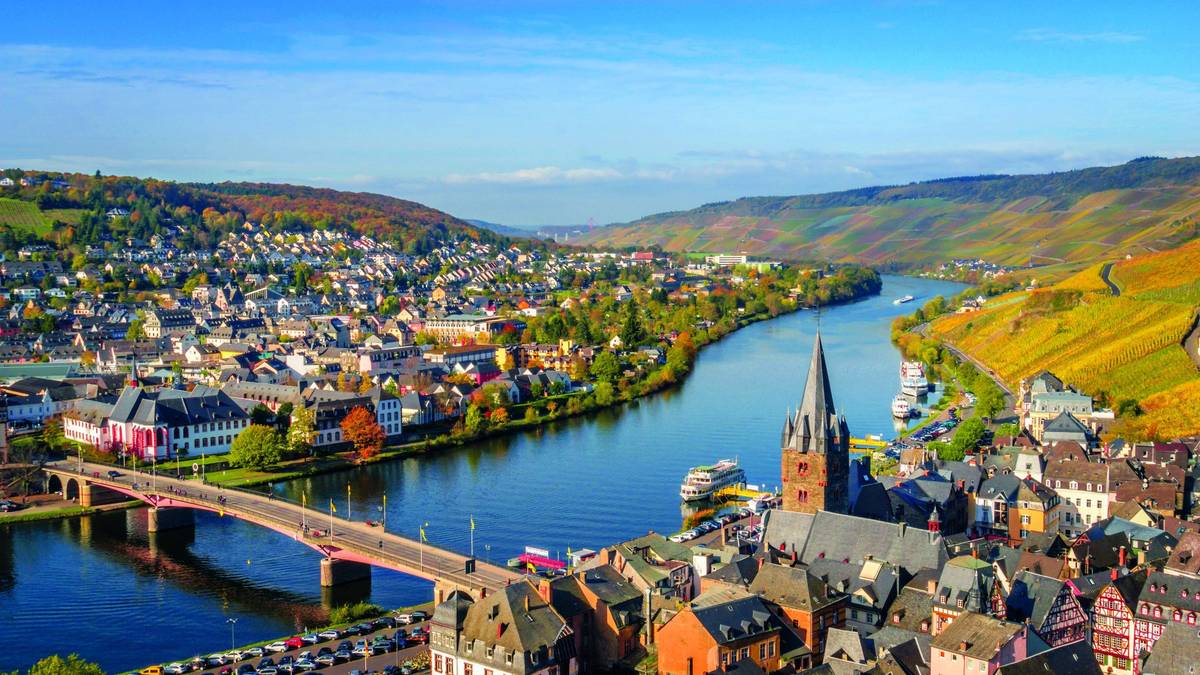 Panoramablick auf Fluss und Stadt mit Feldern und grünen Hügeln