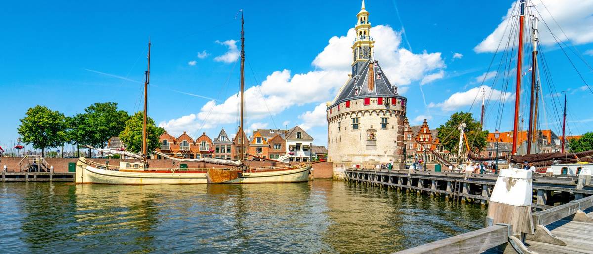 Blick auf Hafen mit anliegenden Schiffen und historischen Gebäuden am Tag mit blauem Himmel