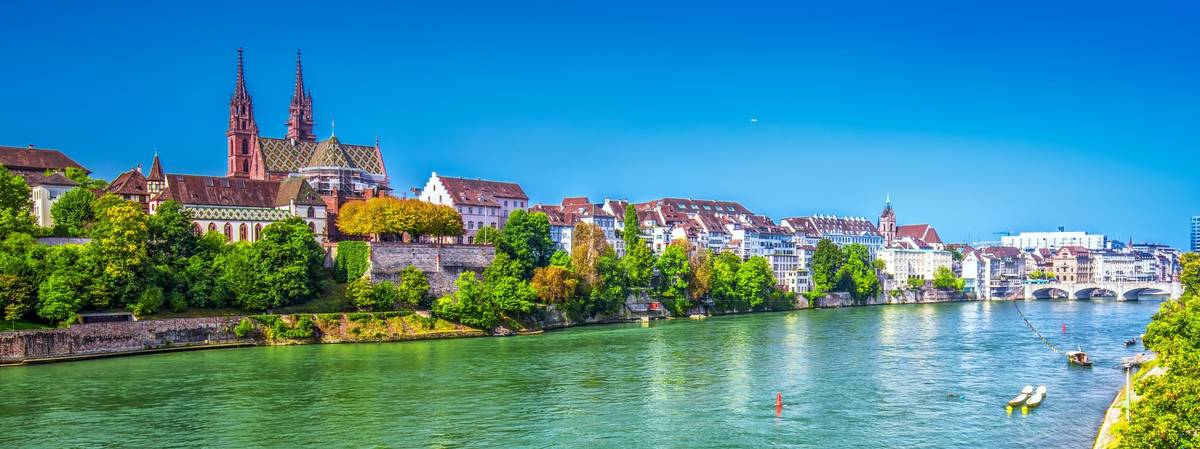 Blick auf historische Stadt an türkisfarbenem Fluss unter blauem Himmel