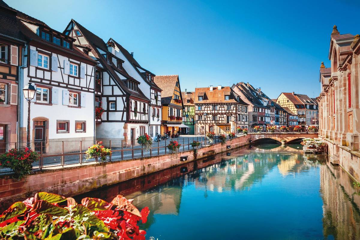 Blick auf Kanal mit historischen Fachwerkhäusern unter blauem Himmel