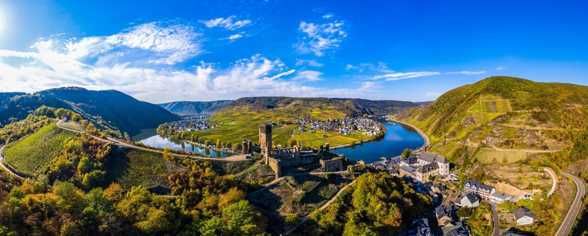 Panoramablick auf Flusskurve mit Weinbergen an Hängen unter blauem Himmel