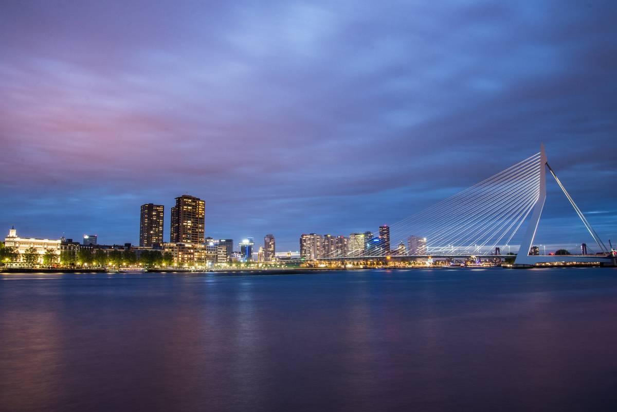 Skyline am Wasser am Abend mit farbenfrohem Himmel und erleuchteten Hochhäusern