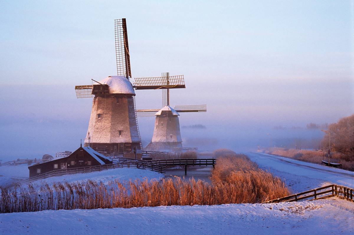 Windmühlen im Winternebel, von Schnee umhüllt