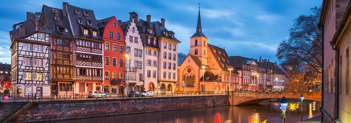 Ansicht auf Kanal mit Häusern und Kirchturm am Ufer und Brücke