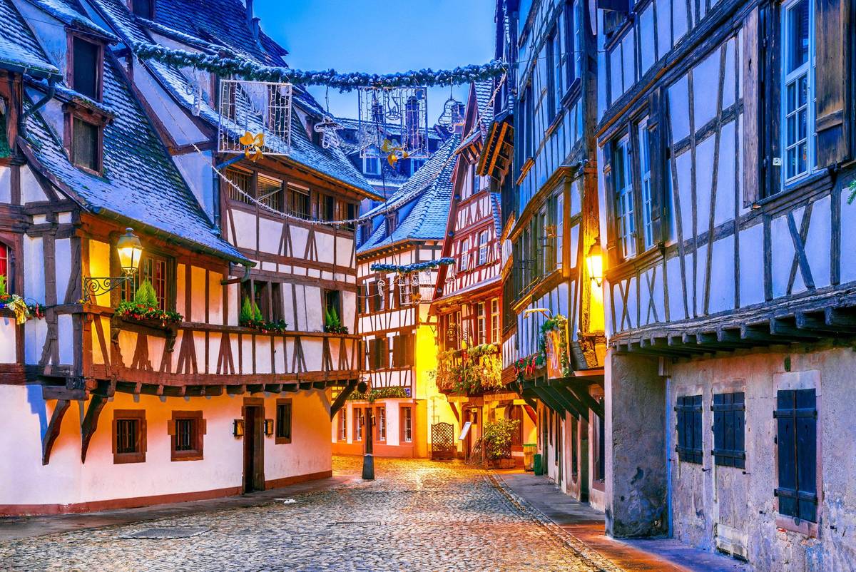Geschmückte Fachwerkhäuser mit weihnachtlicher Beleuchtung im Schnee