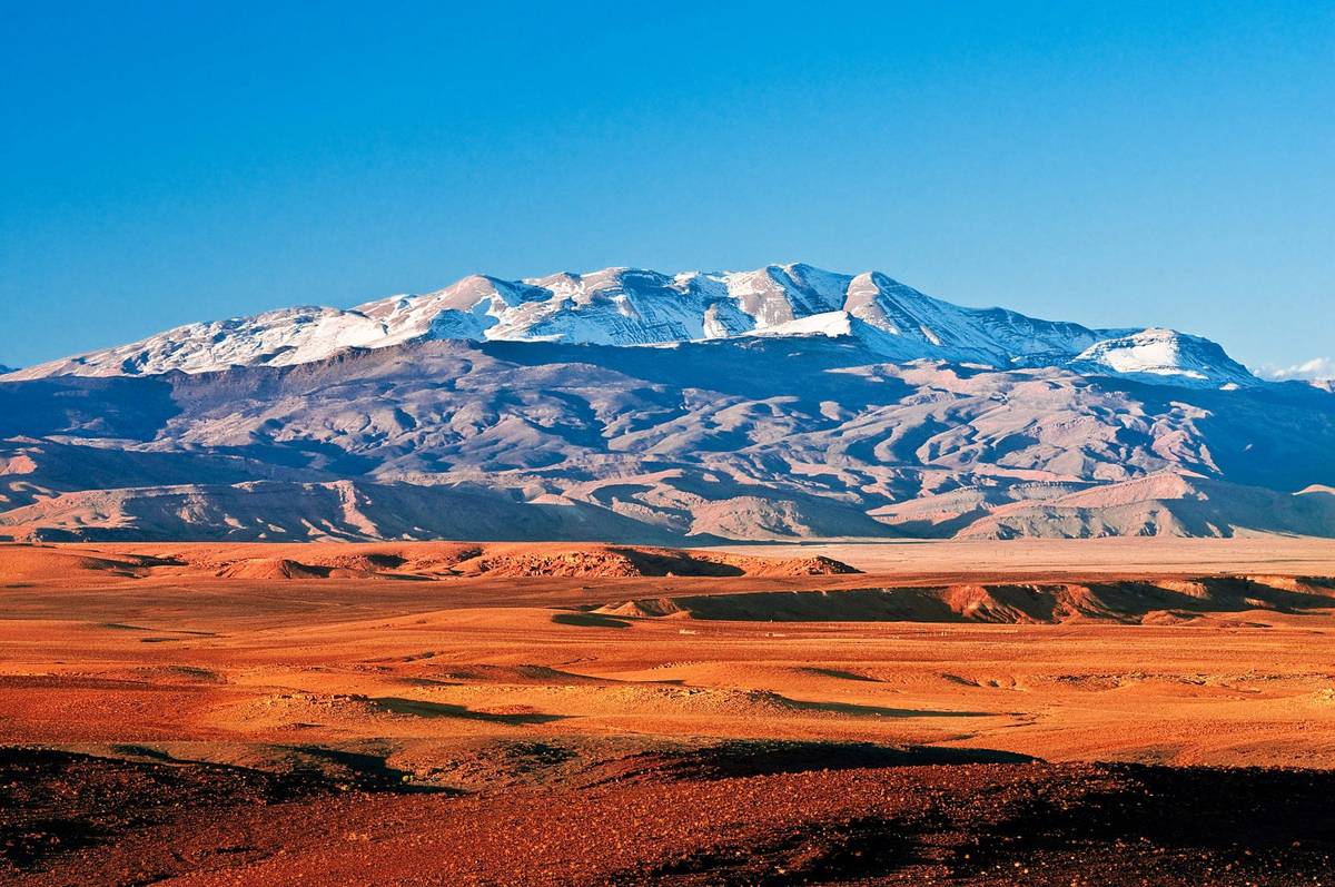 Panoramaaufnahme des Atlas-Gebirges in Marokko mit rotem Wüstensand und strahlend blauem Himmel – eindrucksvolle Landschaft auf einer Marokko-Rundreise