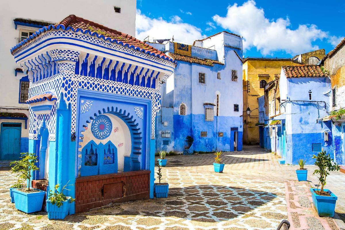 Die blaue Stadt Chefchaouen in Marokko mit typischen Fassaden und klassisch marokkanischem Gehsteinmuster.