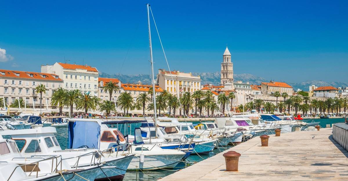 Aufnahme eines Anlegers mit kleinen Segelschiffen im kroatischen Split und Stadtpanorama im Hintergrund