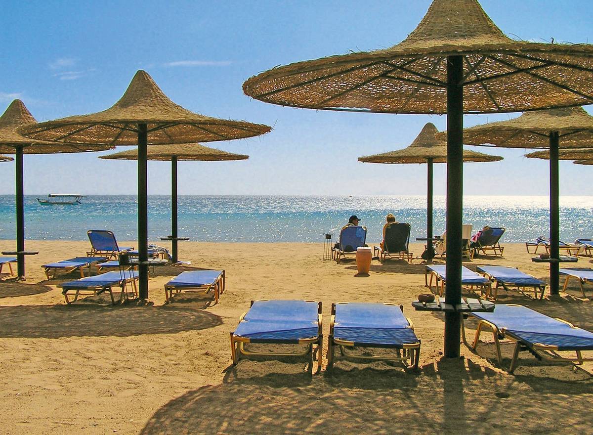 Sonnenschirme und Sonnenliegen am Strand des Roten Meeres