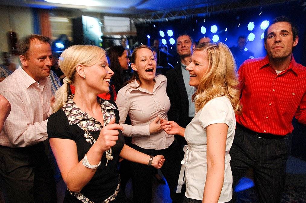 Einige tanzende glückliche Menschen auf einer Partyreise mit Schiff