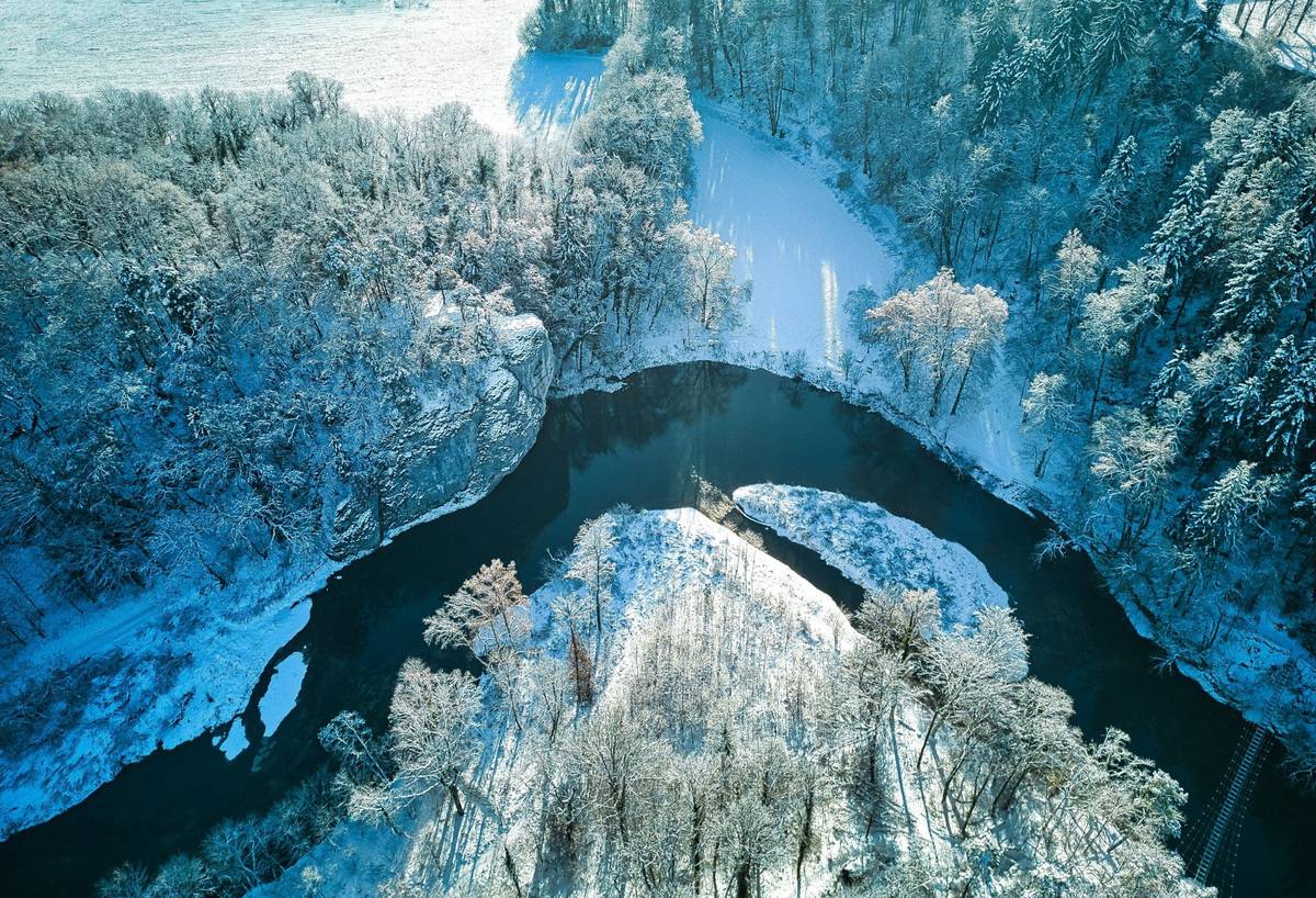 Eine schneebedeckte Landschaft an der Donau bei klarem Himmel