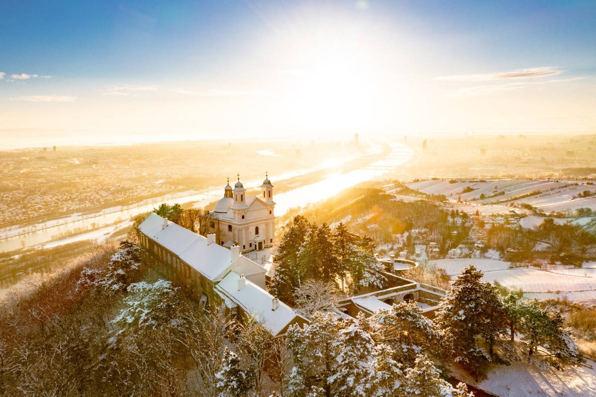 Schneebedeckte Landschaft an der Donau mit einem Ausblick auf die Leopoldkirche
