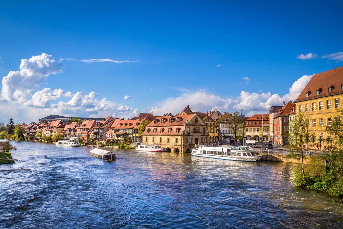 Skyline von Speyer am Rhein mit anliegenden Booten bei blauem Himmel