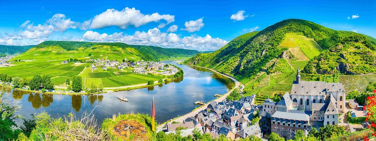 Moselkurve in Beilstein unter blauem Himmel mit grünen Hängen