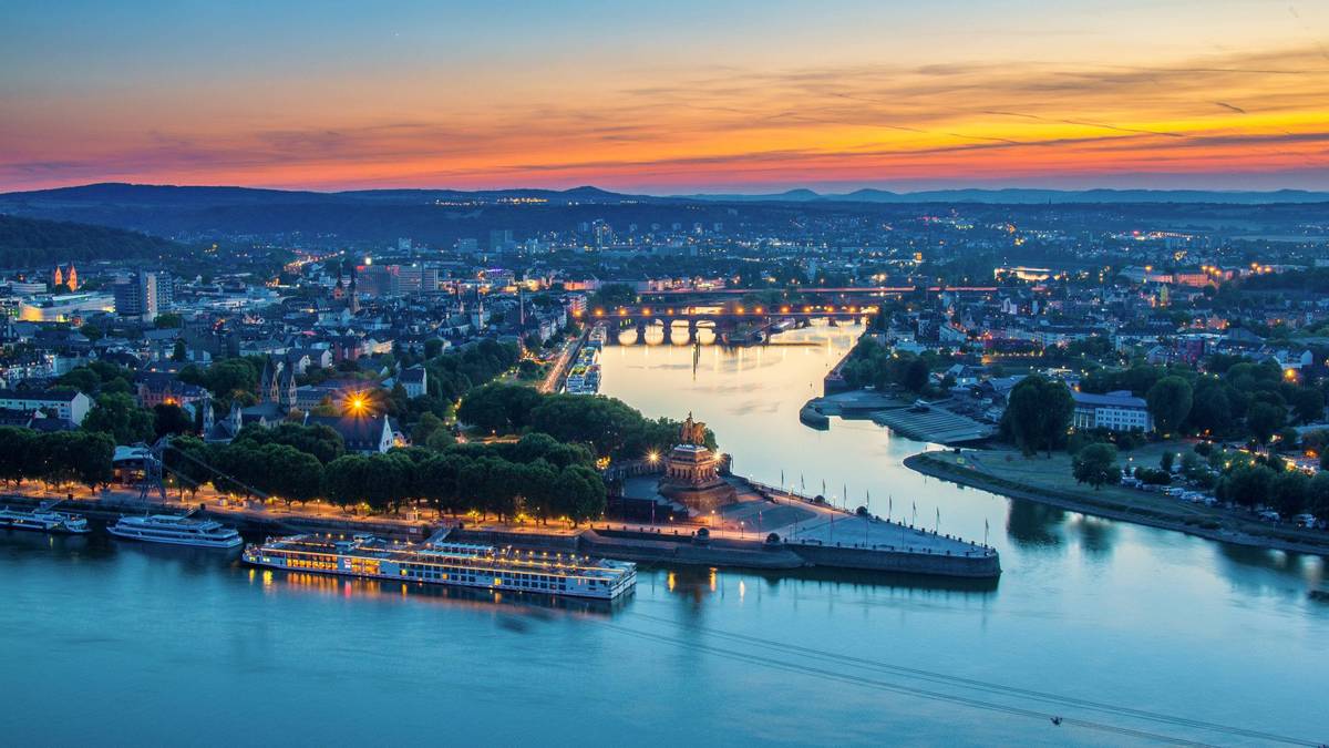 Deutsches Ecks in Koblenz bei Rhein und Mosel während eines Sonnenaufgangs mit blau-orange gefärbtem Himmel