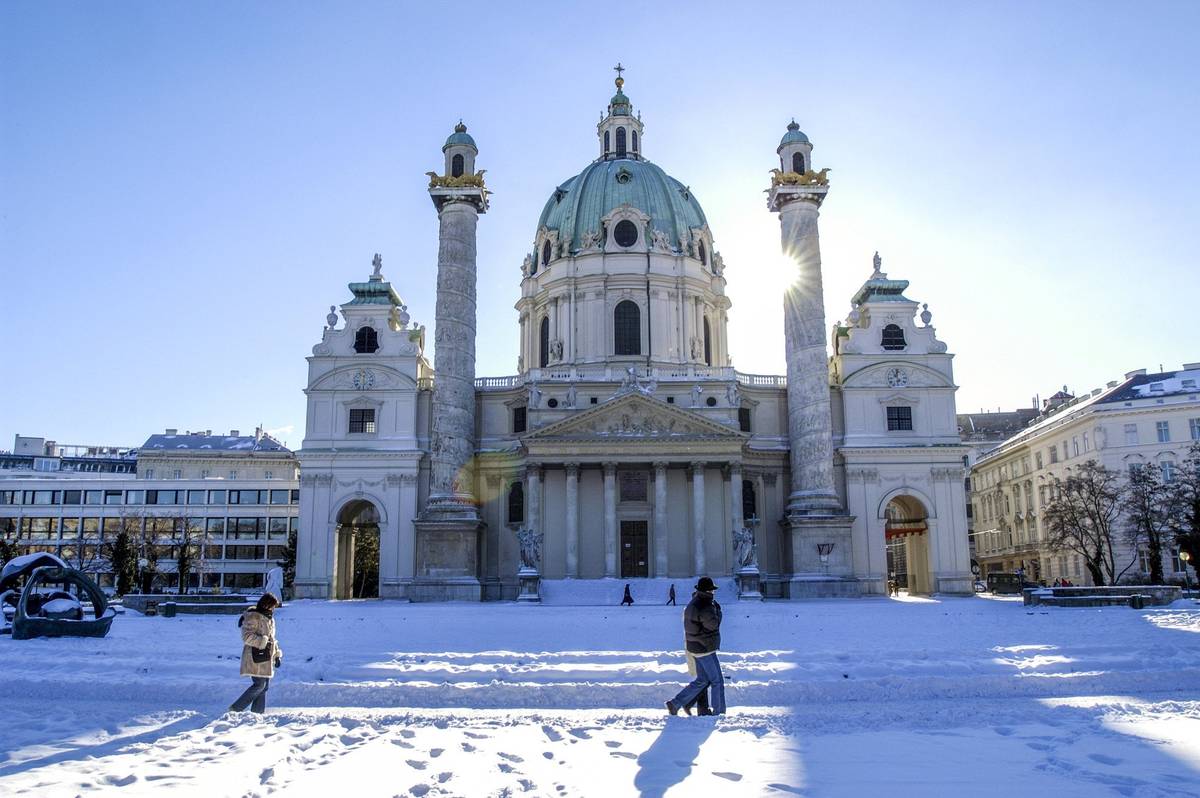 Verschneite Wiener Karlskirche unter blauem Winterhimmel