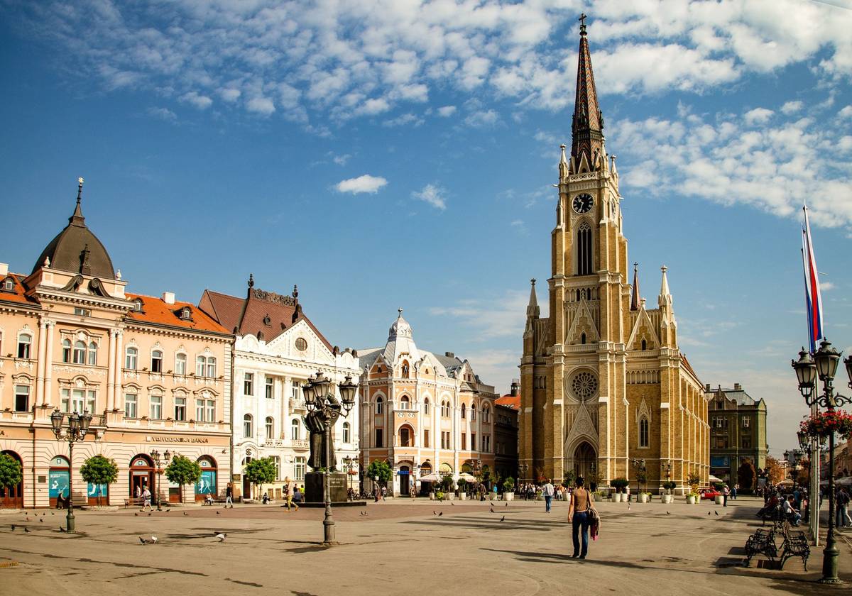 Der Freiheitsplatz im serbischen Novi Sad unter blauem Himmel mit historischer neugotischer Kirche