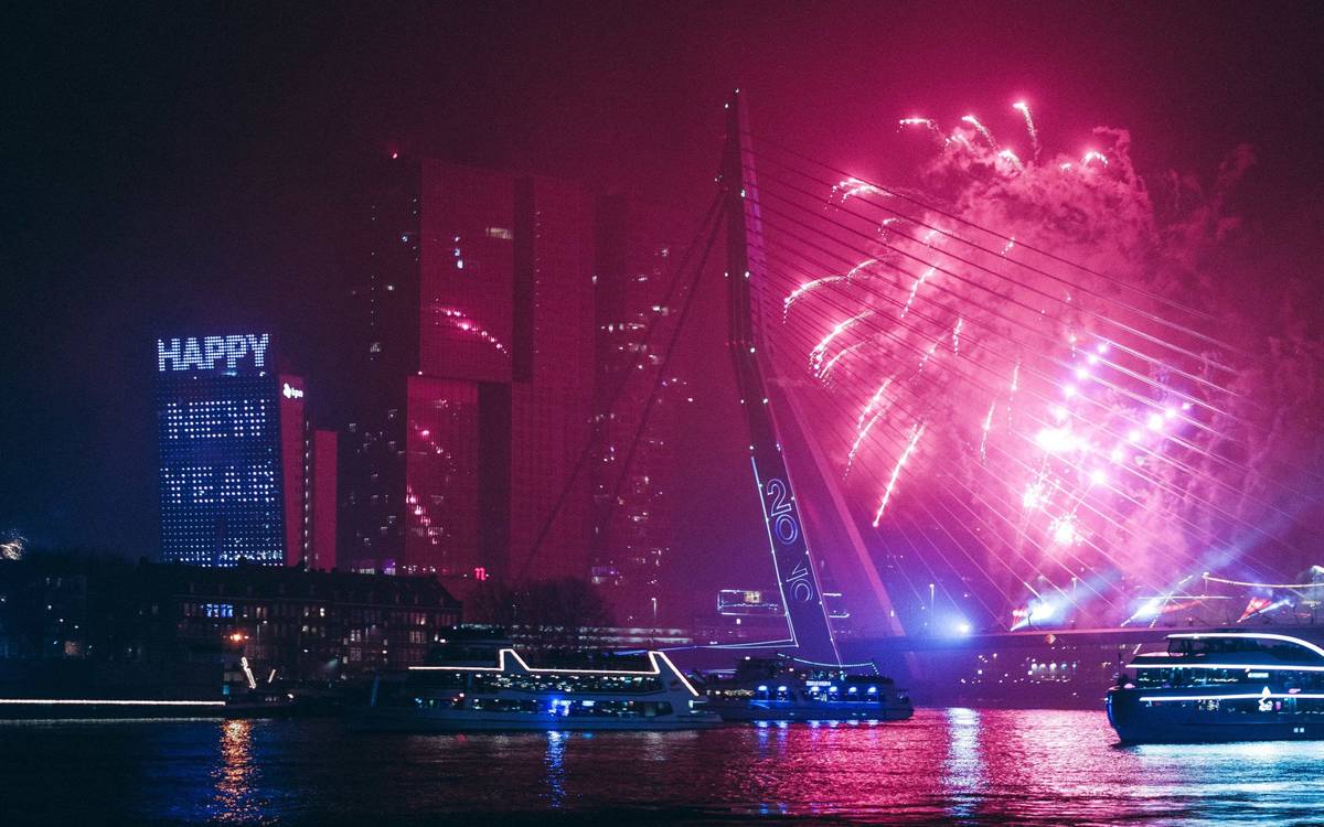 Pinke Feuerwerksrakete über der Erasmusbrücke in Rotterdam während einer Silvesternacht