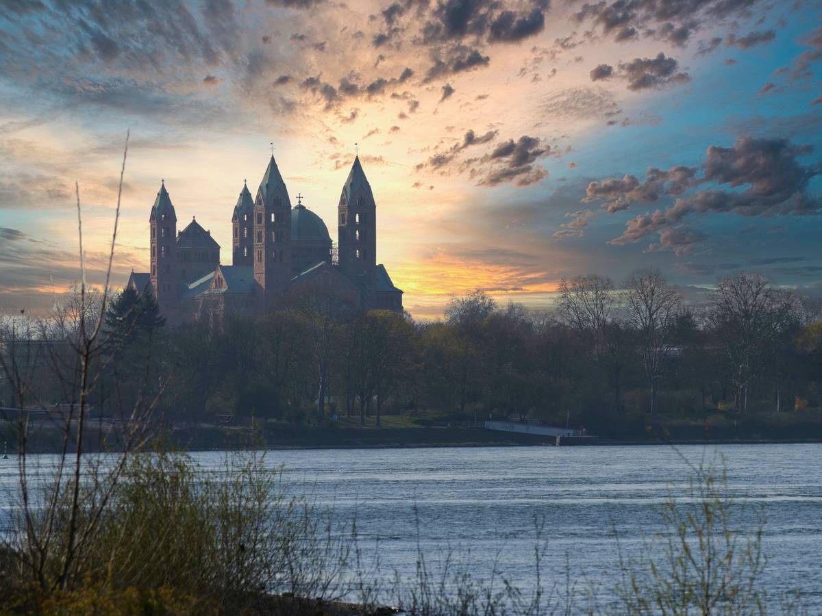 Speyer im Winter am Wasserufer mit Nebel und wolkendurchbrechender Abendsonne