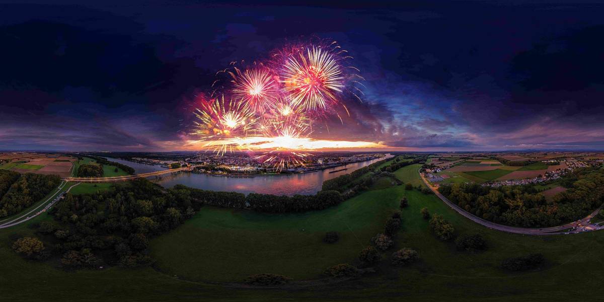 Panoramafoto der Stadt Worms am Rhein mit leuchtendem Feuerwerk an Silvester bei Nacht