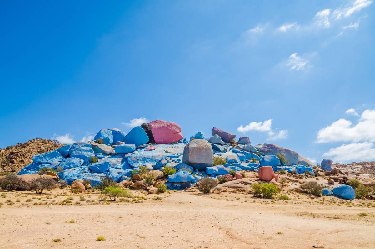 Touristisch beliebtes Ziel "Blaue Felsen" in Tafraoute in Marokko an einem hellen Tag mit fast wolkenlos blauem Himmel