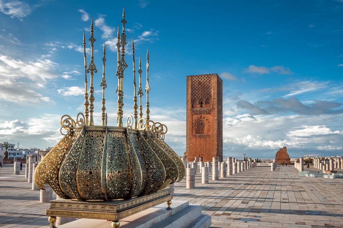 Hassan Turm in Rabat unter blauem Himmel mit einem verzierten Räuchergefäß im Vordergrund. Der Ort bildet eine beliebte Sehenswürdigkeit Marokkos ab
