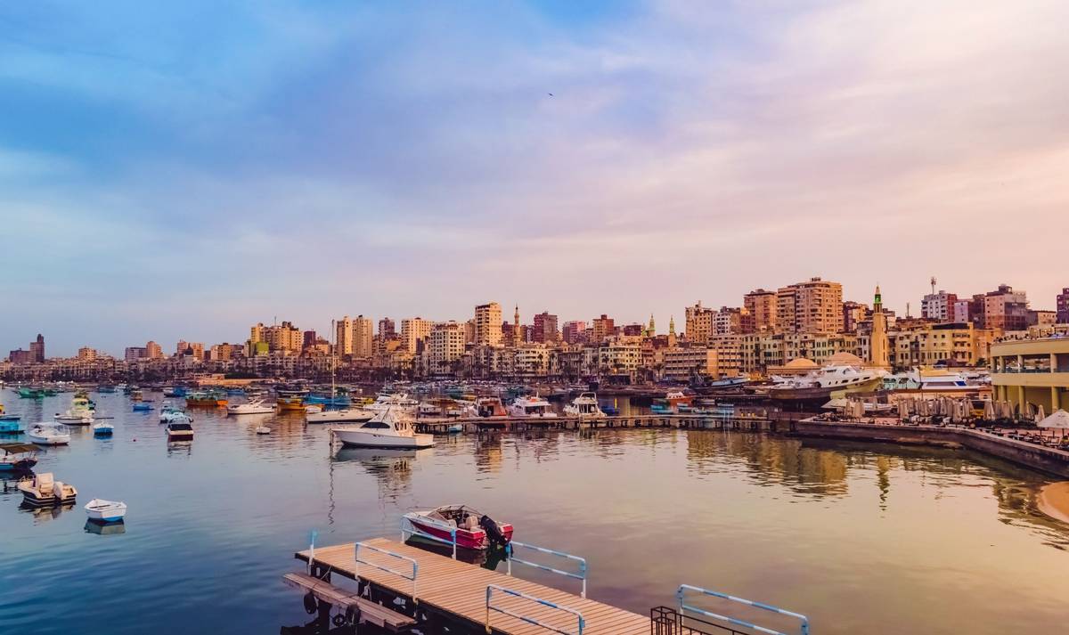 Alexandrische Küste in Ägypten bei Sonnenuntergang im Herbst. Viele im Wasser liegende Motorboote runden das Küstenpanorama ab.
