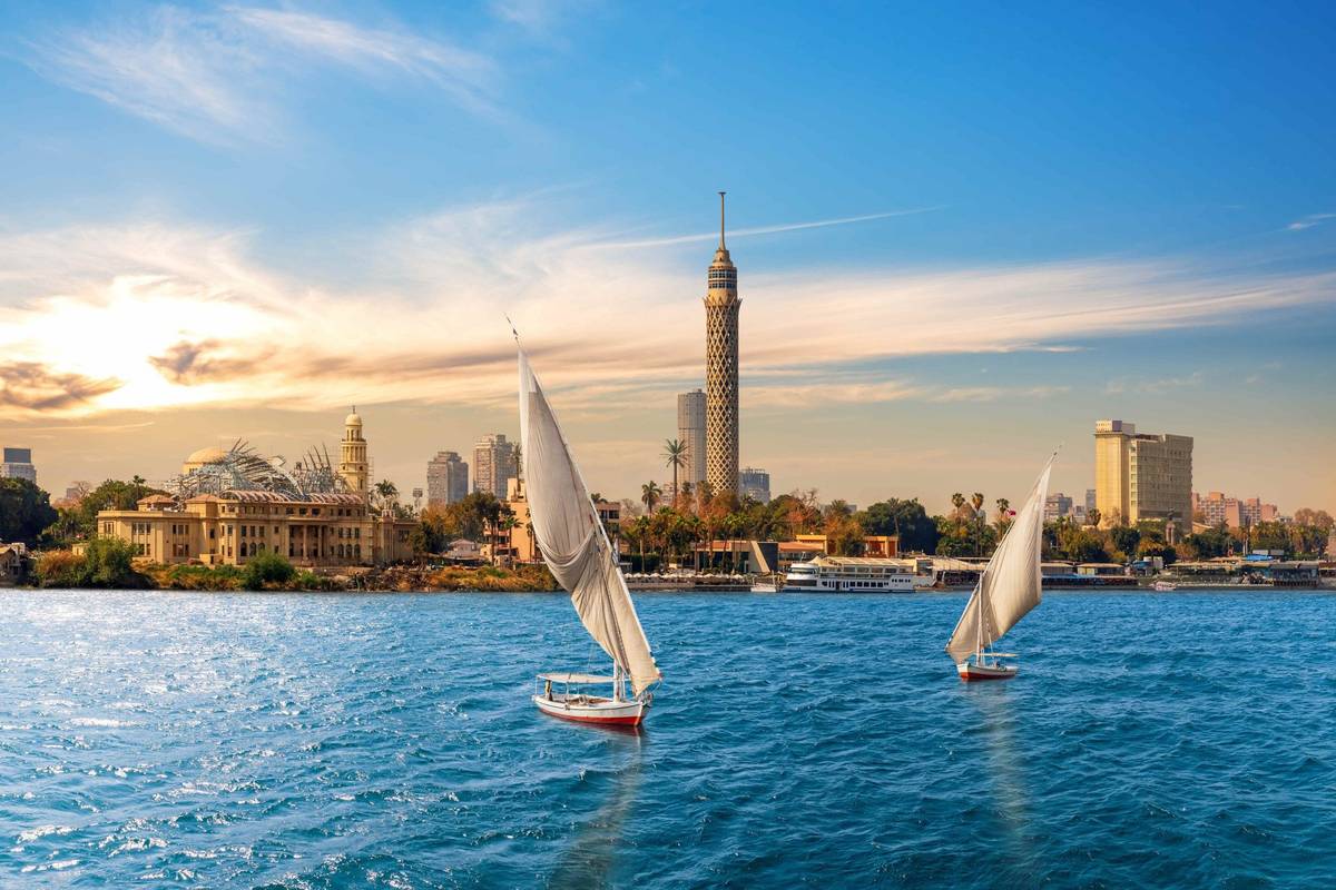 Zwei Felukken auf dem Fluss Nil in Ägypten mit der Skyline von Kairo im Hintergrund inklusive des Fernsehturms