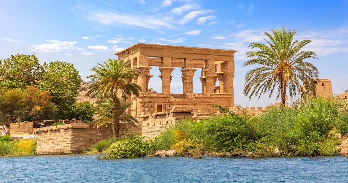 Philae Tempel in Assuan vom Nil aus aufgenommen mit umsäumenden Palmen