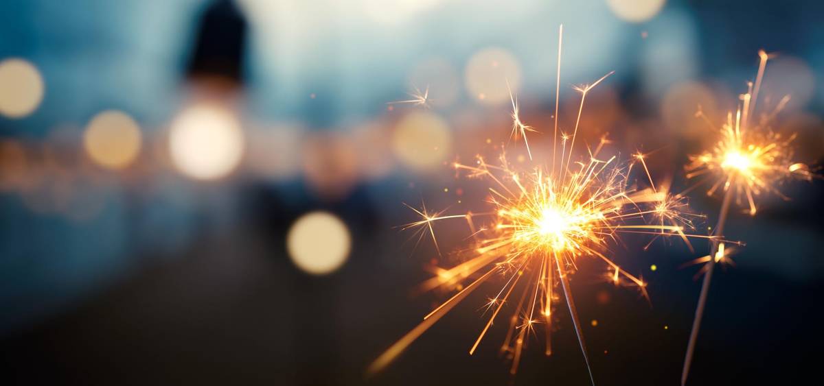 Silvesterfeier mit brennender Wunderkerze in der Hand