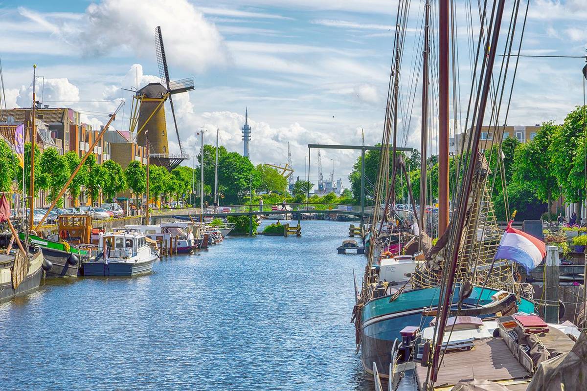 Historischer Oudehafen in Rotterdam mit Segelboten und Windmühle im Kanalrand
