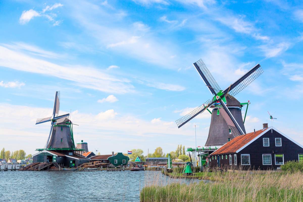 Typisch holländische Windmühlen am Seitenarm des Rheins bei klarem Himmel und herrlichem Wetter.