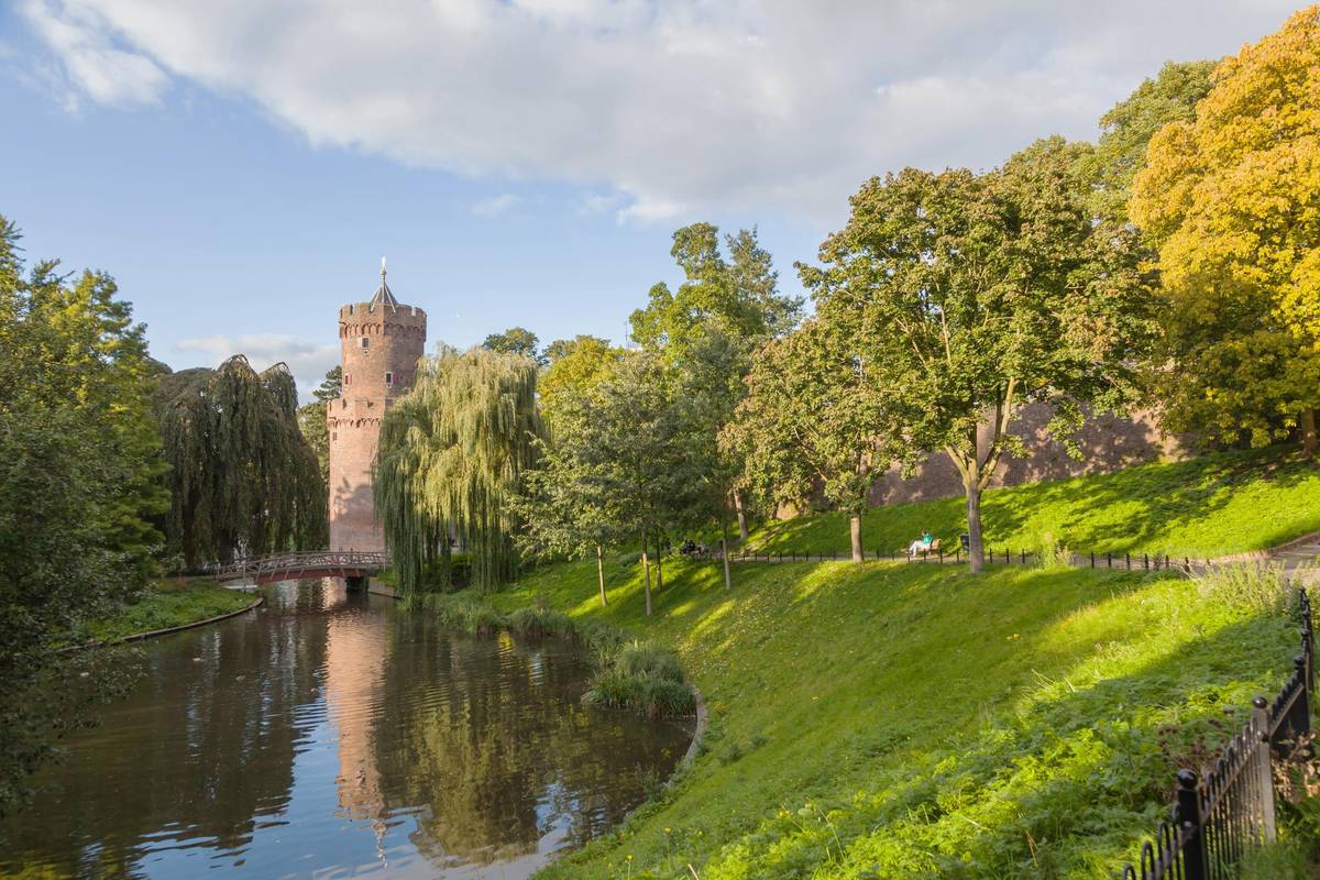 Die historische Burg im Kroneburger Park in Nijmegen nahe der Altstadt. Das alte Gebäude steht an einem kleinen See inmitten von Büschen und Bäumen.