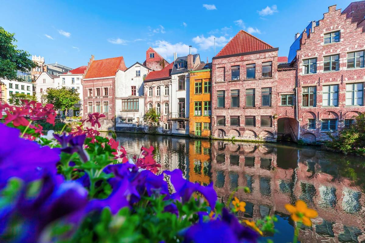 Häuser an einem Kanal in der Altstadt von Gent bei sonnigem Wetter