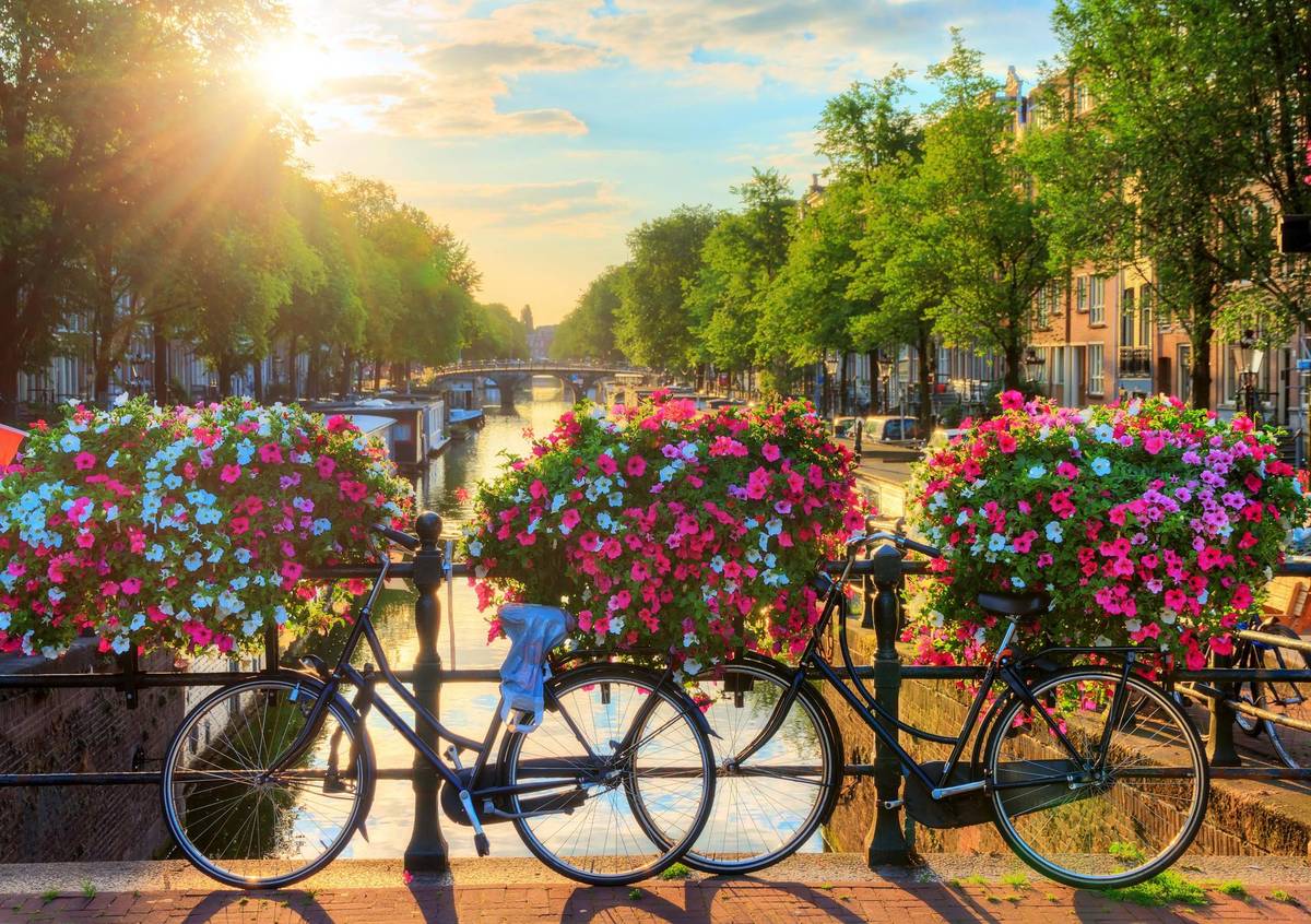 Amsterdam Fahrräder auf Brücke über Kanal mit historischen Grachtenhäusern im Hintergrund